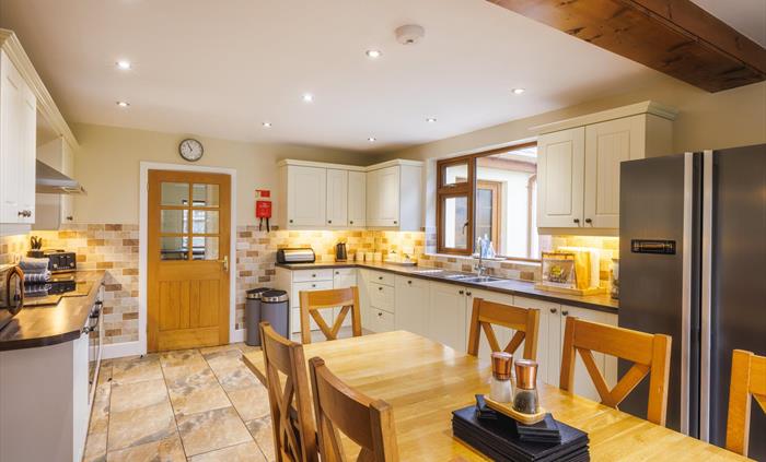 Farmhouse kitchen with shaker-style cupboards and large dining area.